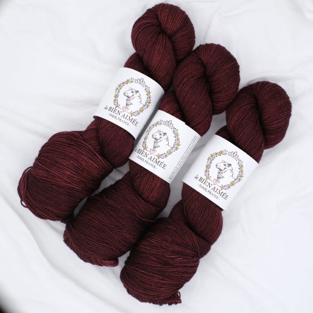 Trzy precle luksusowej włóczki La Bien Aimee Merino Super Sock w głębokim bordowym kolorze Acajou