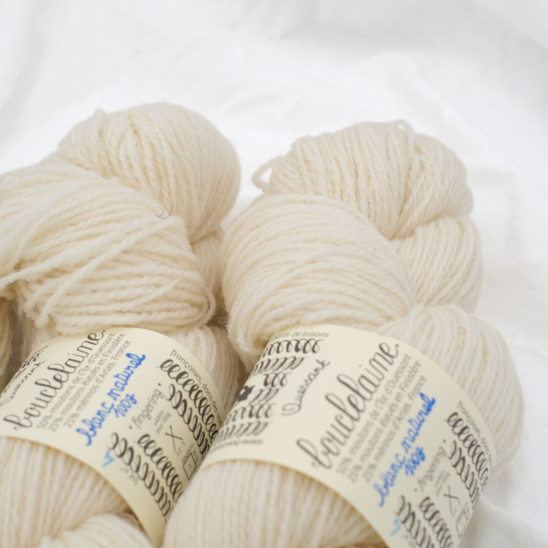 Zbliżenie na jasny motek francuskiej przędzy Bouclelaine Ouessant kolor Blanc Naturel