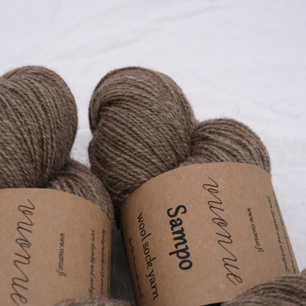 Zbliżenie na beżowy motek naturalnej przędzy Vuonue Sampo Undyed w odcieniu Beige z etykietą