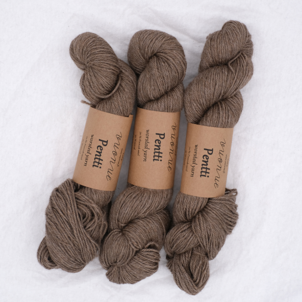 Trzy precle beżowej włóczki Vuonue Pentti Undyed w naturalnym kolorze Beige na jasnym tle