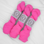 Trzy precle neonowo-różowej włóczki skarpetkowej La Bien Aimee Merino Super Sock w odcieniu Kool