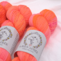 Zbliżenie na neonowo-pomarańczowy motek ręcznie farbowanej włóczki skarpetkowej LBA Merino Super Sock kolor Tang